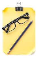 notepad with pencil and glasses