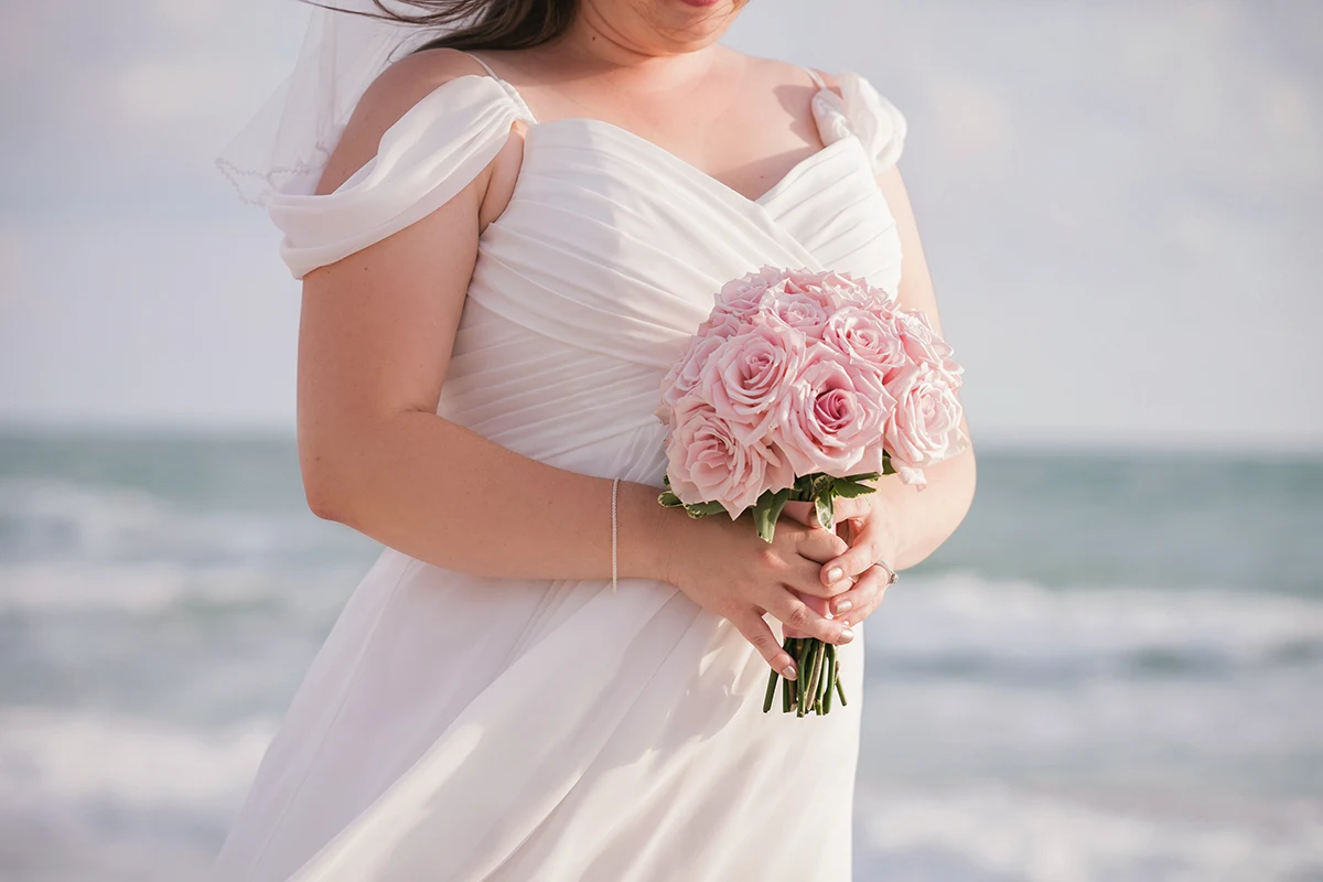 plus-size woman in a wedding dress holding bouquet