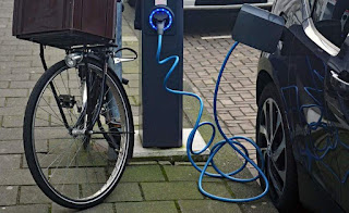 image: A bicycle leans against an electric vehicle charging station in Amsterdam. (Credit: mariordo59, CC BY-SA 2.0) Click to Enlarge.