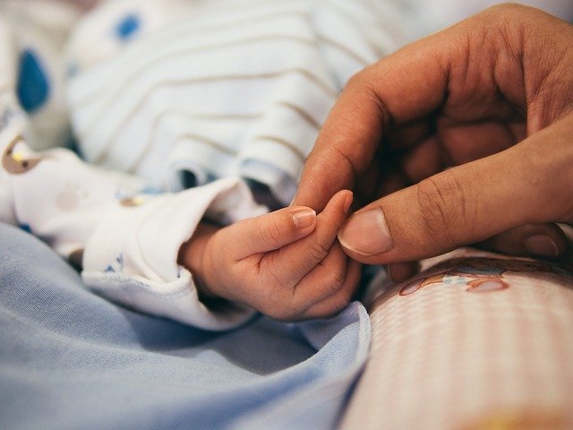 Picture of baby's hand with parents hand