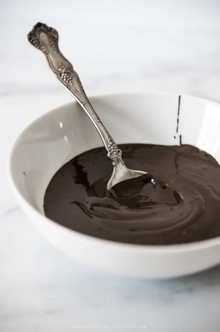 White bowl with melted chocolate and spoon