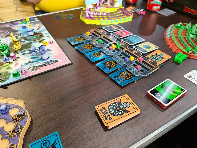 picture of the card layout from fractured sky board game showing ten cards laid out in a grid with two piles of cards sitting off to the side. 