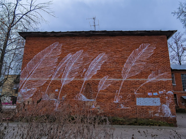 Перья на стене кирпичного здания