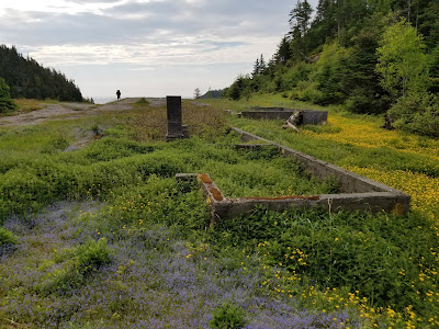 Foundations of La Manche village in grassy field.