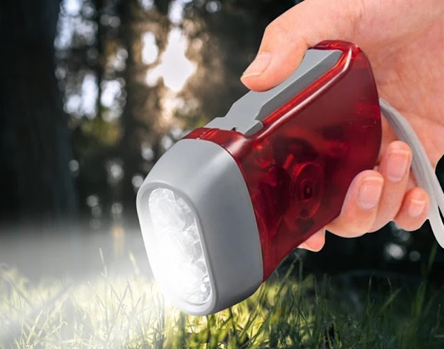 person holding wind up flashlight