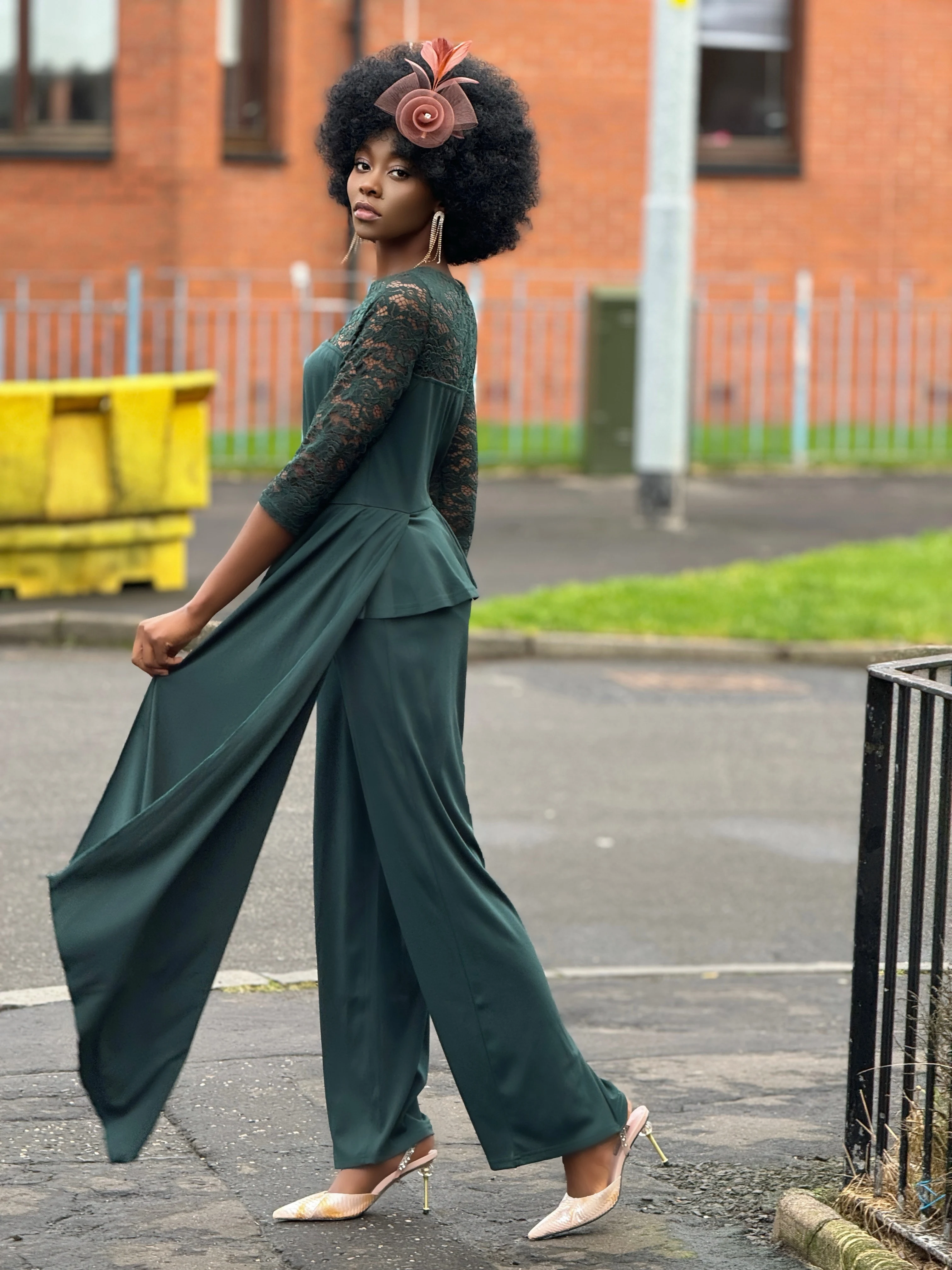 Woman wearing green jumpsuit with lace sleeves, showcasing versatile styling options.