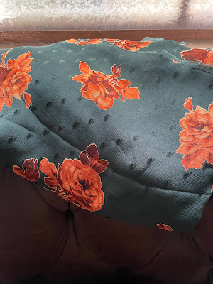 a piece of dark sea green viscose with bright orange flowers