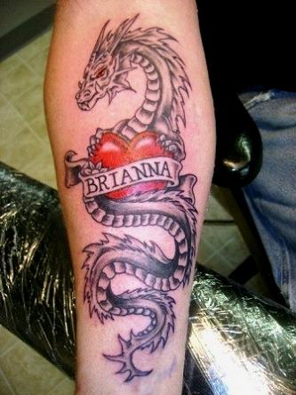 Red heart and dragon tattoo on arm.