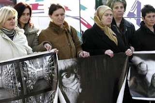 Relatives of Srebrenica victims hold photos relating to the massacre as they prepare to leave Sarajevo in Bosnia early Saturday, Feb. 24, 2007 for the Netherlands to attend Monday's verdict by the International Court of Justice in a genocide case against Serbia and Montenegro in the Hague. Bosnia-Herzegovina filed the case in 1993 — the first time a state, rather than individuals, had been charged with genocide. In case it wins, it hopes later to seek compensation for the loss of life and property during the 1992-95 war, when over 100,000 people were killed and when entire Muslim Bosniak towns and villages were devastated.