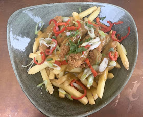 skinny fries in a bowl loaded with katsu chicken curry and chillies