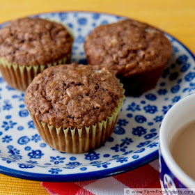 pic of banana cookie butter oatmeal muffins on a plate with a mug of tea