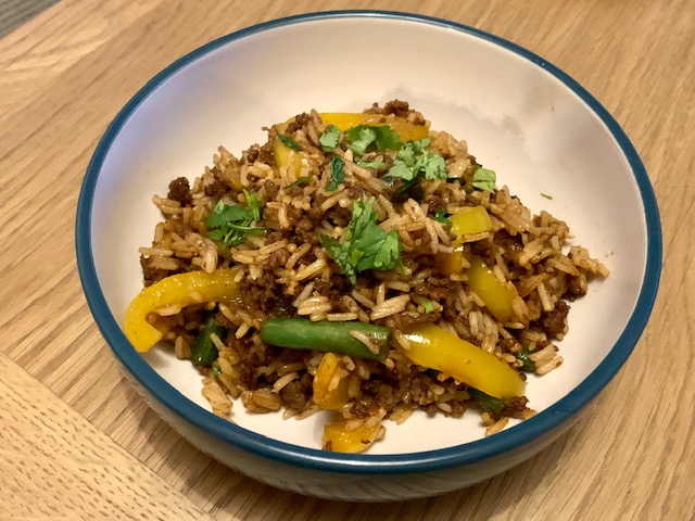 Bowl of beef fried rice, with peppers and green beans