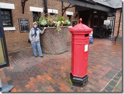 Elaine at a large flower pot near the Gloucester Waterway Museum