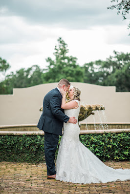 bride and groom kiss in front of fountain