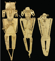 Three tunjos from the Gutiérrez offering. Each figure, including all their elements, was cast in a single pour. The earrings received the metal through feeders that connected them to the figure shoulders, and the ‘stumps’ left after cutting these feeders can still be seen (one of them is indicated by an arrow). The two figures on the left still carry the casts of the main feeders attached to their feet, as these were never cut. Remains of charcoal and clay from the mould are still visible in some areas, such as the necklace of the left figure or the eyes of the middle one. The tallest figure is c. 17 cm in height. 