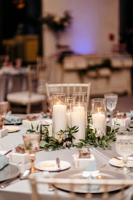 wedding reception centerpiece with cylinder vases, greenery and candles