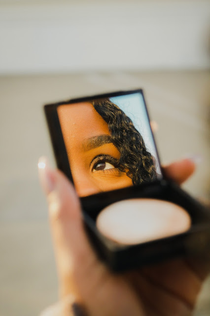woman looking into small mirror:Photo by Peter Kalonji on Unsplash
