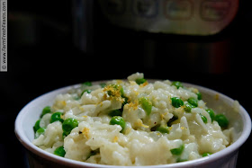 photo of a meatless springtime main dish of pressure cooked risotto with peas and parmesan, accented with lemon