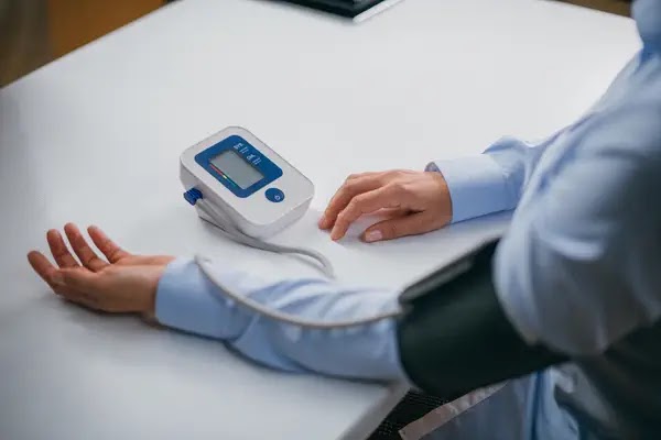 Person measuring blood pressure - Lifestyle Changes and Medication for Blood Pressure Control