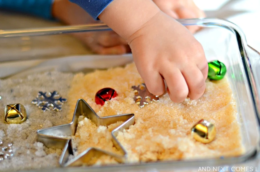 Playing with gold & silver epsom salts in a Christmas sensory bin from And Next Comes L