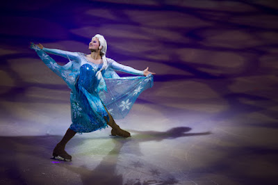 Elsa skates across a rink at a peformance of Disney on Ice Into the Magic