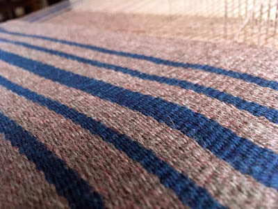 A close-up of grey and teal striped weft-faced fabric, showing the slight warm heathering in the grey yarn and the depth of color in the teal.