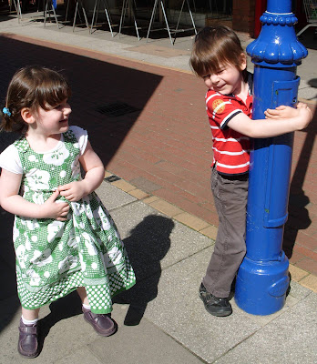 Leaning on a lamp-post.