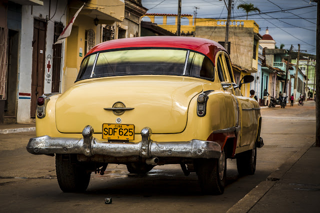 a classic yellow car parked in a street of Trinidad, Cuba