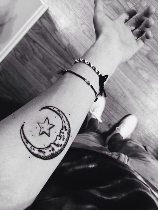 Uma personificação da lua crescente quadros de um ponto cinco estrelas em esta tatuagem tinta para o usuário do antebraço.