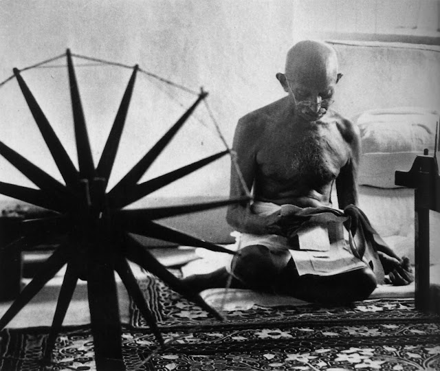 Gandhi atras de uma roda fiar. Essa foi uma das ultimas fotos dele antes de seu assassinato algumas horas depois