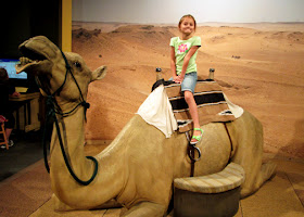 A snapshot of Tessa on a life-size model of a camel at "Lost Egypt."