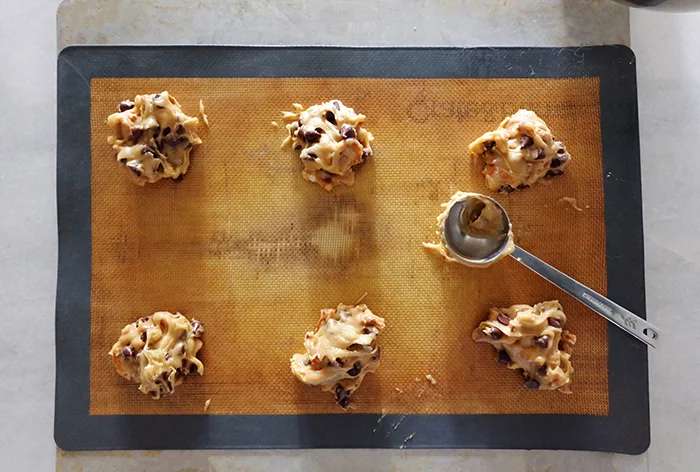 balls of cookie dough on lined baking sheet