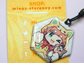 A charm made by an online store called Mi-eau, showing a shiba inu girl