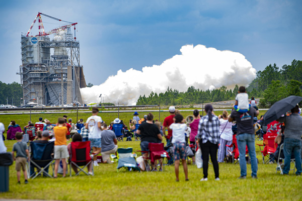 A crowd of NASA employees and family members watch as a next-generation RS-25 engine is tested on the Fred Haise Test Stand at NASA's Stennis Space Center in Bay St. Louis, Mississippi...on June 15, 2023.