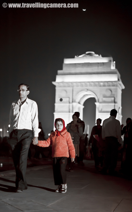 A child holding the father's hand around India Gate in Delhi. There is no better way to discover your city.