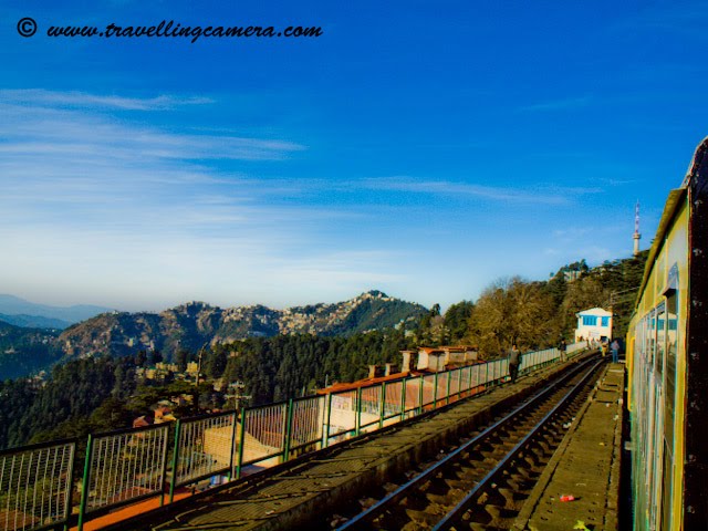 Travelling Camera @ Shimla Railway Station, Himachal Pradesh (Waiting for Himalyan Queen for back journey to Kalka): POSTED BY VJ SHARMA AT www.travellingcamera.com : Shimla Railway Station is under the administrative control of Northern Railways. It is located about 3.25 kilometers from Chotta Shimla. It has a narrow gauge railway line linked to Kalka (92 kilometers) on which the toy trains run. The journey on the toy train offers amazing experience to the travellers. Shivalik Express, Shimla Mail and Kalka Shimla Rail Motor Car (special train) pass through this station. Computerized reservation facility is provided...Himalyan Queen Waiting @ Shimla Railway Station...Don't miss the Doordarshan Tower on hill-top in this Photograph...A view of other side of Shimla.. Probably Chhota Shimla...A few minutes walk from the station is Shimla Bus Station. Just 2.5 kilometers from the railway-station is the Mall Road which is main attraction among Tourists in Shimla. The nearest airport is Shimla Airport at Jubbalhatti which is around 25 kilometers from Railway Station...A View of deep valley from Himalyan Queen @ Shimla Railway Station.Its time to depart from Shimal and forget this freshness...Main Entry to Shimla Railway Station...The route offers a panoramic views of the amazing Himalayas from the Sivalik foot hills at Kalka to several important points such as Dharampur, Solan, Kandaghat, Taradevi, Barog, Salogra, Summerhill and Shimla at an altitude of 2100 meters...