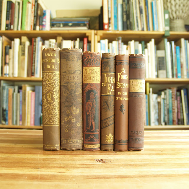 Six antique books in brown and red decorative bindings