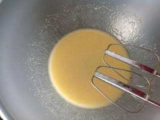 beaten egg and oil in bowl with paddles of whisk