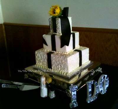 A lovely black and white cake accented with a yellow sunflower