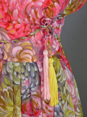 Tassels hang from a bow at the waist of this 1960s silk evening gown by 