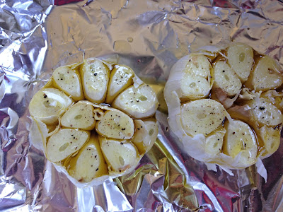 Trimmed garlic bulbs coated with olive olive and seasoned with salt and peppe