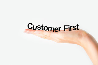 The words "customer first" are on a giant hand to denote the right customer service strategy