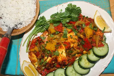 Platter of stir fried paneer with peppers with a bowl of rice.