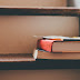 Old books stacked on top of a ladder