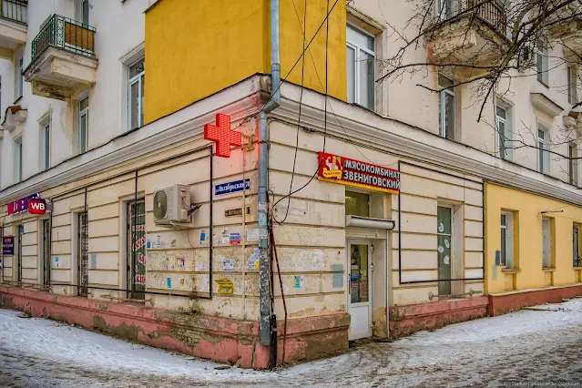 Пошарпанный угол сталинки с вывеской аптеки
