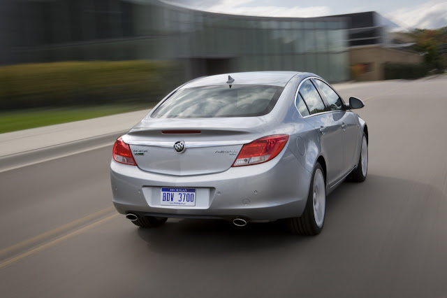 Rear 3/4 view of silver 2011 Buick Regal driving on city street