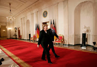 President George W. Bush and German Chancellor Angela Merkel leave Cross Hall at the White House, Thursday evening, Jan. 4, 2006, following their joint news conference. White House photo by Paul Morse.