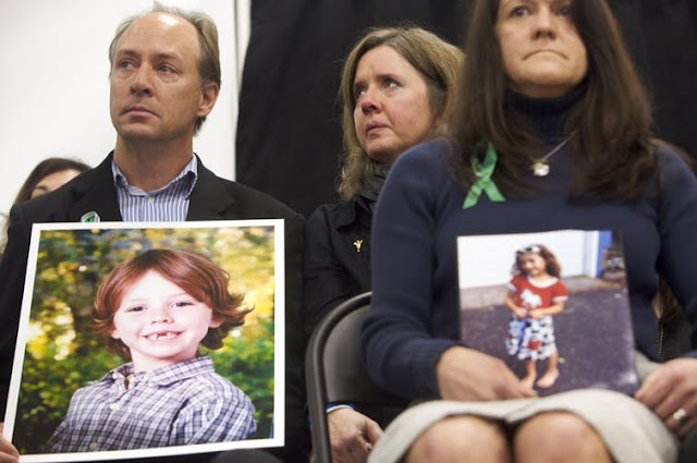 Mark Barden and Jennifer Hensel hold photos of their respective children Daniel Barden, 6, and Avielle Richman, 6, both victims of the Sandy Hook shooting.