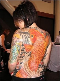 KOI TATTOO - Probably surprising to many westerners is the large of amount of ancient myth that surrounds these beautiful fish in the Orient and their elevated status there. Generally known here as the brightly colored fish that are common in public ponds and fountains, carp (koi is Japanese for carp) can be found in colors that include white, yellow, gold, a deep orange, and some are even calico-colored. Particularly beautiful specimens have been known to fetch prices in excess of half-a-million dollars from private collectors who specialize in their breeding and showing. 