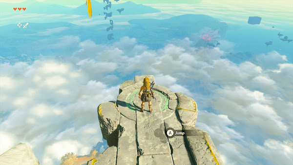 Screenshot, Link stands on broken and mossy rock projection with ring of glowing green text. He's looking out over the clouds of Hyrule, with a few floating islands scattered and a menacing glow under the clouds off to his right. 